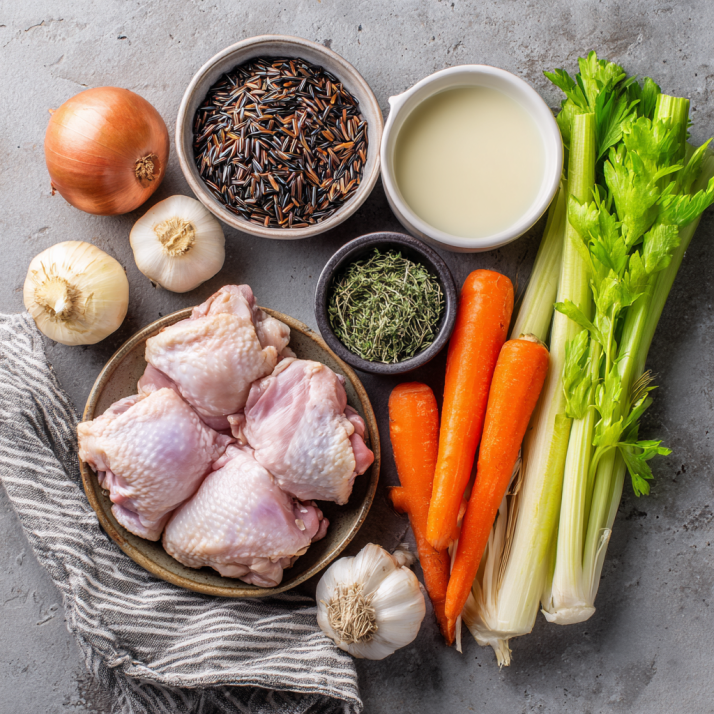 ingredients for chicken and wild rice soup on wooden surface