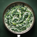 Easy creamed spinach recipe in a skillet with fresh spinach in creamy white sauce