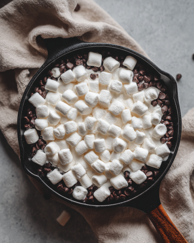Preparing easy s’mores dip with chocolate and marshmallows in skillet