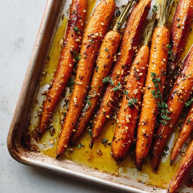 Honey roasted carrots on a baking sheet with caramelized glaze