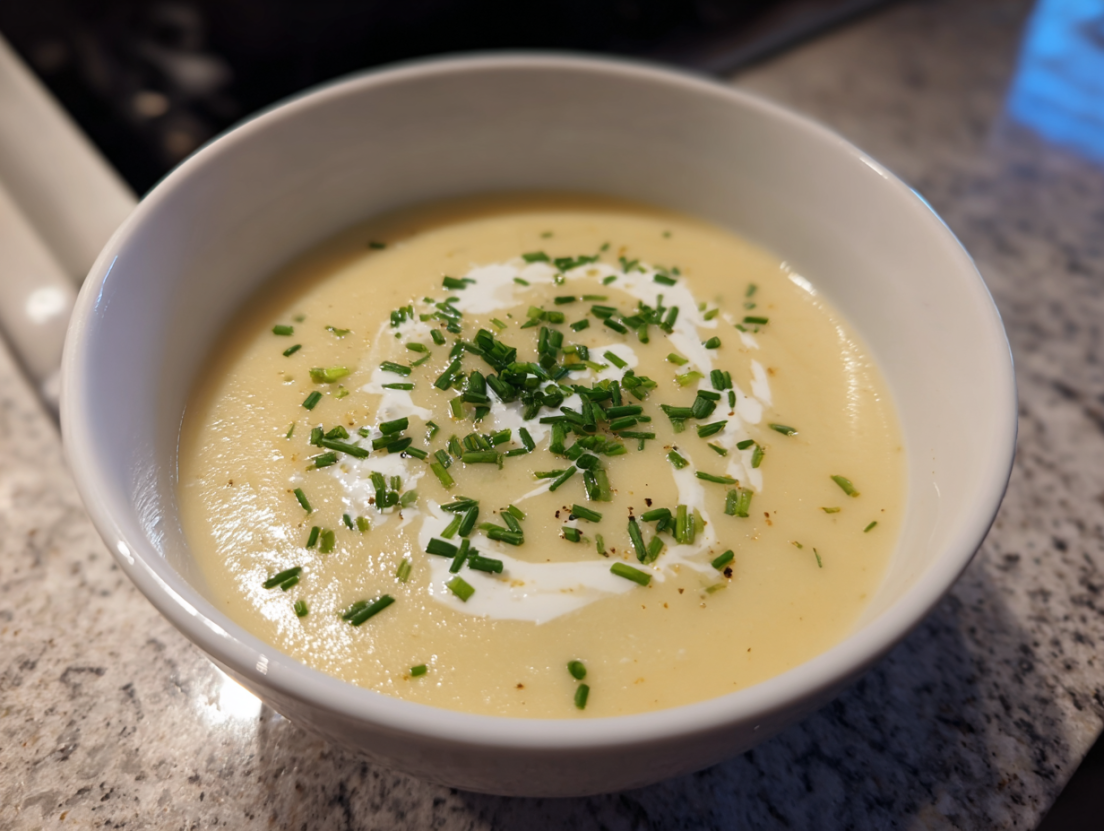Light creamy cauliflower soup served in a rustic bowl with herbs