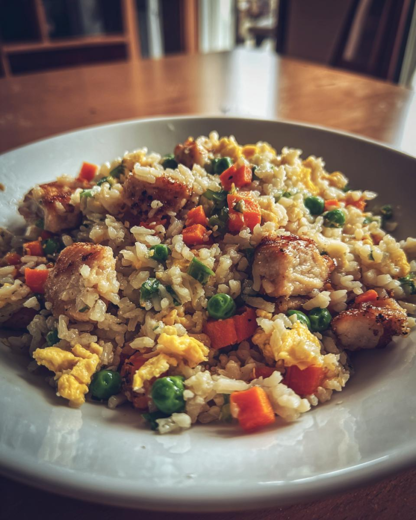 Chicken fried rice family comfort food recipe with chicken, rice, eggs, peas, and carrots